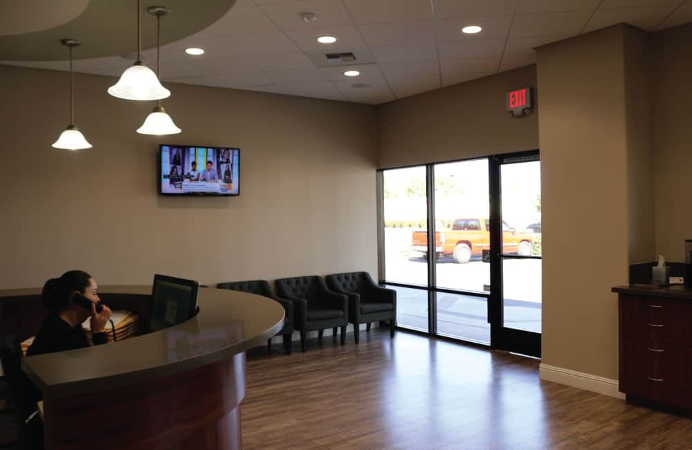 The reception area of a new desert office, designed with contemporary decor and expansive windows offering desert views.