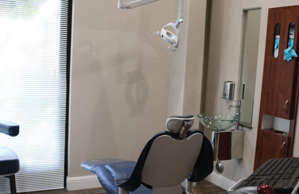 A dental office scene at American Family Dentistry, highlighting a patient chair and a computer for efficient dental care.